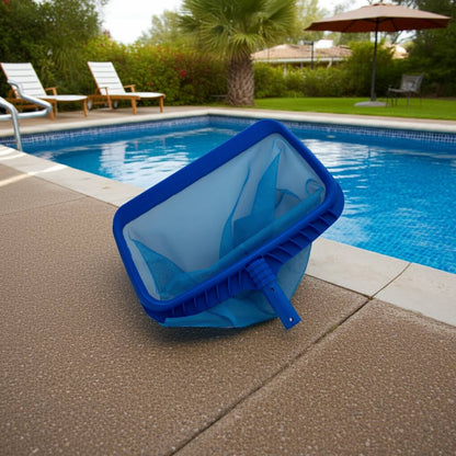 Blue pool skimmer net on a pool deck with a pool and lounge chairs in the background.