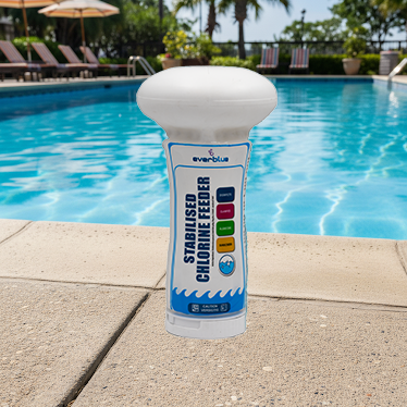 Everblue pool chlorine feeder on a poolside ledge with a pool and chairs in the background